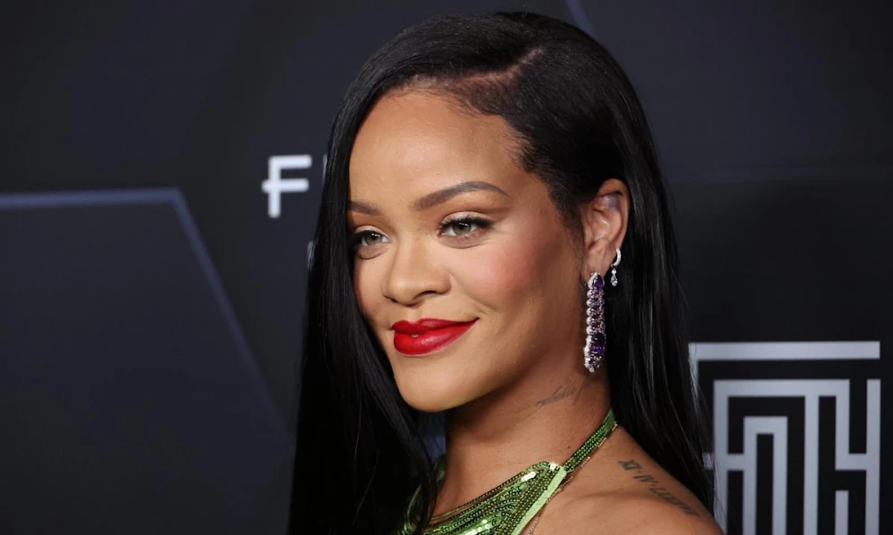 | Fenty Beauty: The Complete Guide to Rihanna's $2.8 Billion Beauty Empire (2025) Close up profile of Rihanna wearing signature red lipstick at a red carpet event