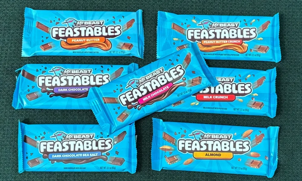 | Feastables: MrBeast's $250M Chocolate Empire & Why It's More Profitable Than YouTube An open display of various packaged flavors of MrBeast Feastables chocolate bars side by side