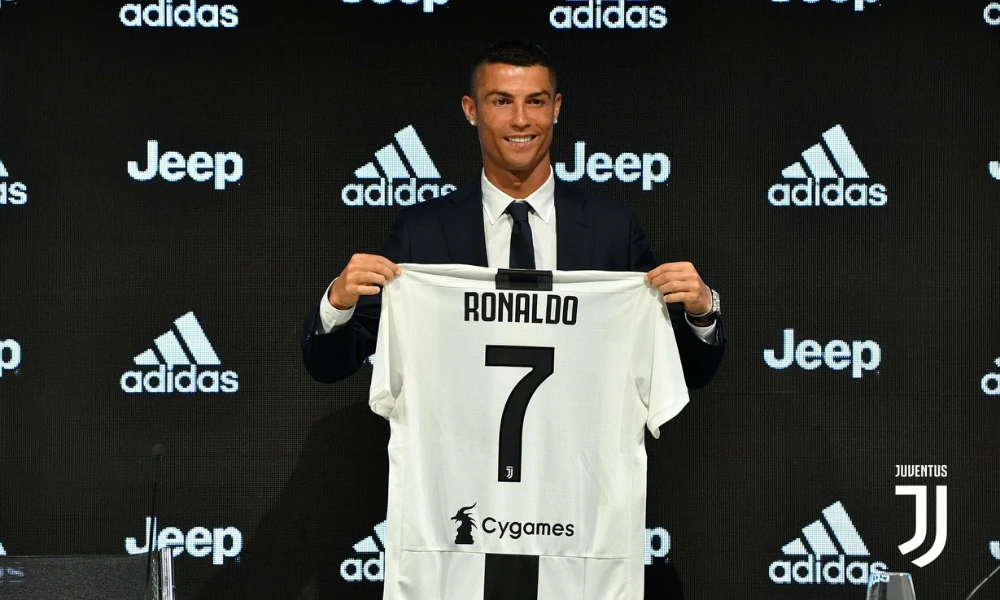 | CR7: The Complete Guide to Cristiano Ronaldo's Brand Empire (2026) Cristiano Ronaldo presenting the official number 7 jersey during a club press conference event