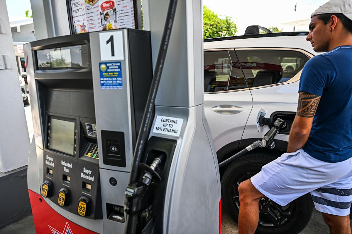 | Inflation Topped 4% as Gas Prices Push Economic Pressure Higher A side view of a customer refueling a white car at a gas pump terminal with an ethanol notice sticker