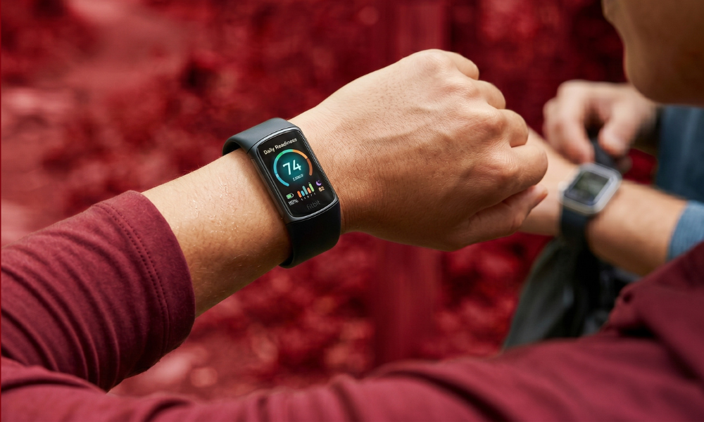 | Fitbit vs Garmin vs Apple Watch: Which Fitness Tracker is Worth It? A close up view of a user checking the Daily Readiness Score index menu on a sleek Fitbit tracker band