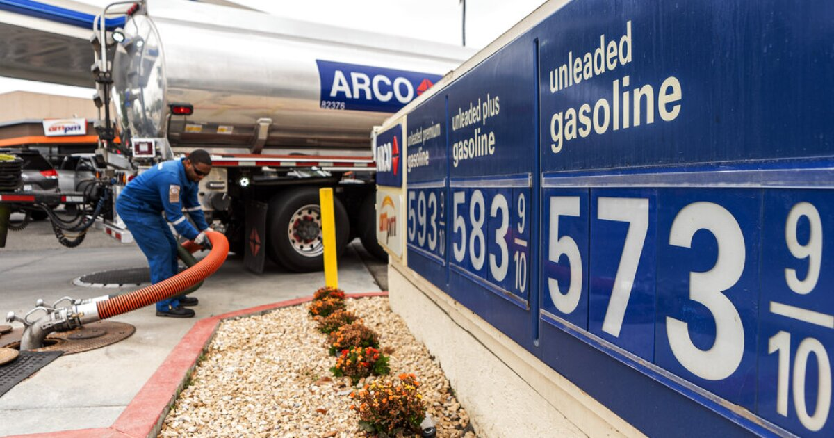 | Inflation Topped 4% as Gas Prices Push Economic Pressure Higher An ARCO fuel delivery truck driver pumping fuel at a gas station displaying premium unleaded pricing tiers above five dollars