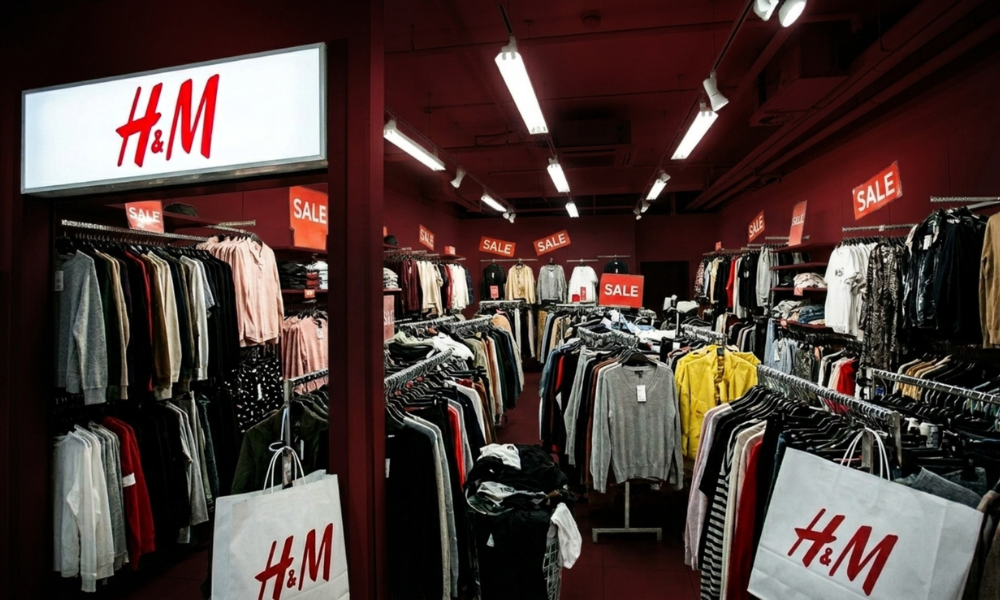 | Zara vs. H&M: Fast Fashion's Digital Marketing Duel, Who Owns the Feed in 2026? H&M retail clothing store interior layout featuring red seasonal discount sale signage and clothing racks