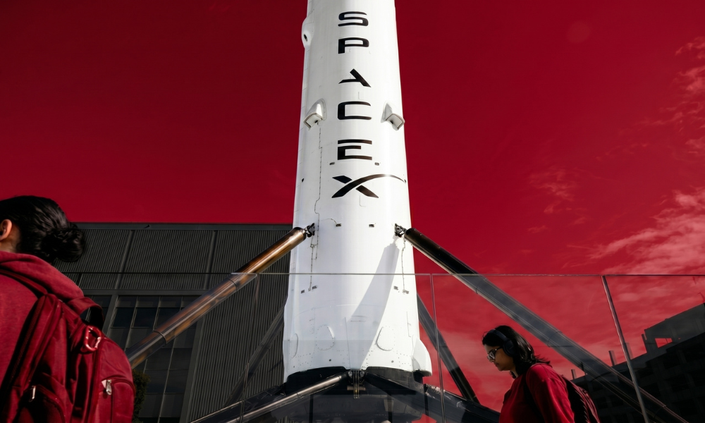 | Elon Musk's SpaceX Begins Trading in Record-Breaking IPO: The Complete $75 Billion Deep Dive (2026) A massive white vertical SpaceX rocket booster core structure on a landing pad platform