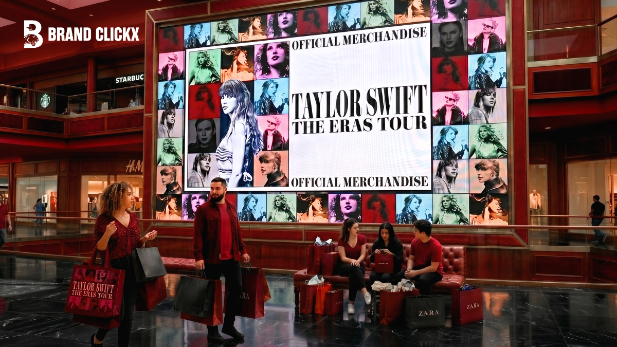 A massive Taylor Swift Eras Tour official merchandise digital billboard display inside a luxury shopping mall with consumers holding branded shopping bags by BrandClickX