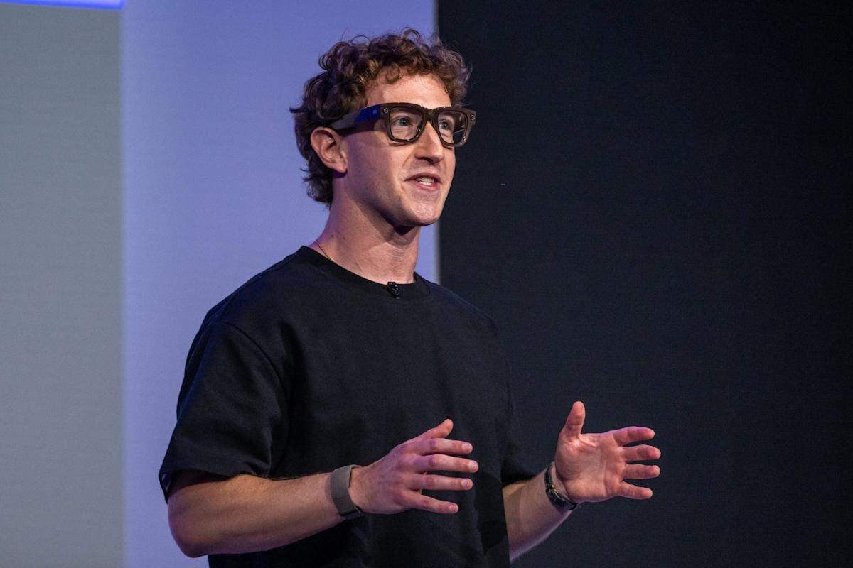 | Meta Launches $299 AI Glasses in Wearables Push Meta CEO Mark Zuckerberg wearing smart glasses and gesturing during a technology keynote presentation on stage