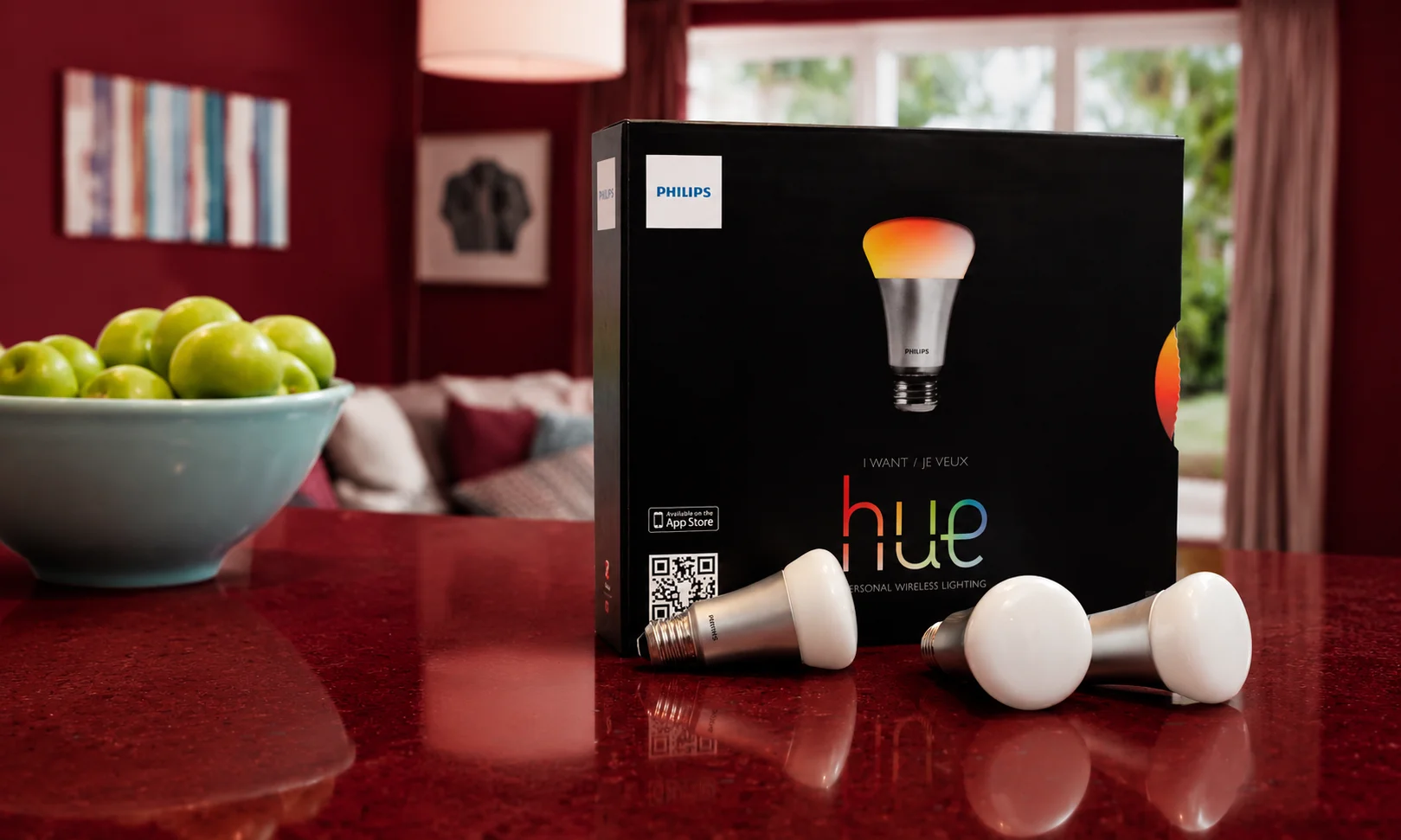 Philips Hue smart lighting box and bulbs on red surface