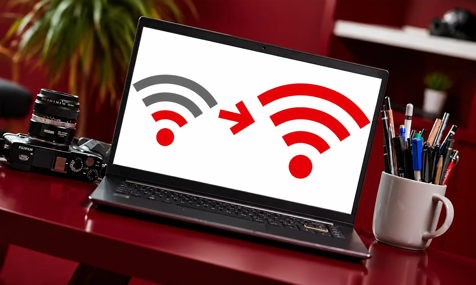 Laptop with weak Wi-Fi signal indicator in red-lit room