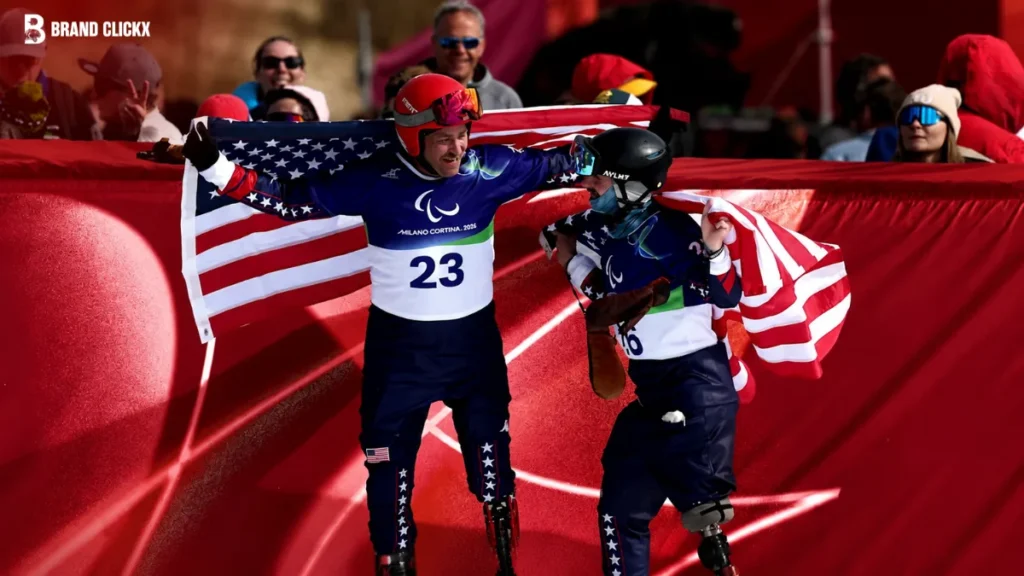 Athletes celebrating during the 2026 Winter Paralympics with an American flag in the background