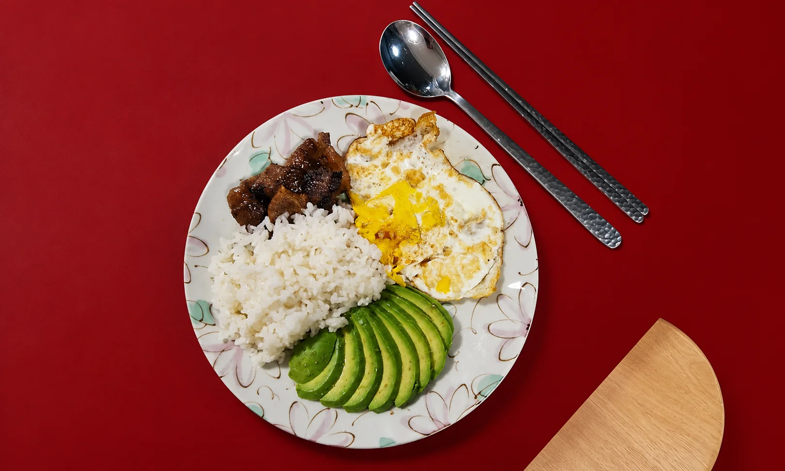 Healthy plate with avocado and eggs on red surface
