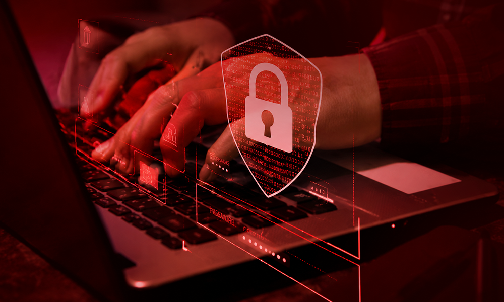 | 6 Lesser-Known Tech Brands Crushing It in Cybersecurity Person working on a laptop with a digital lock icon for cybersecurity