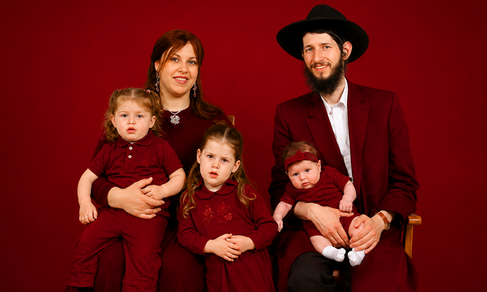 | 150+ Jewish Last Names and Their Origins Explained A family group portrait set against a professional deep red background.