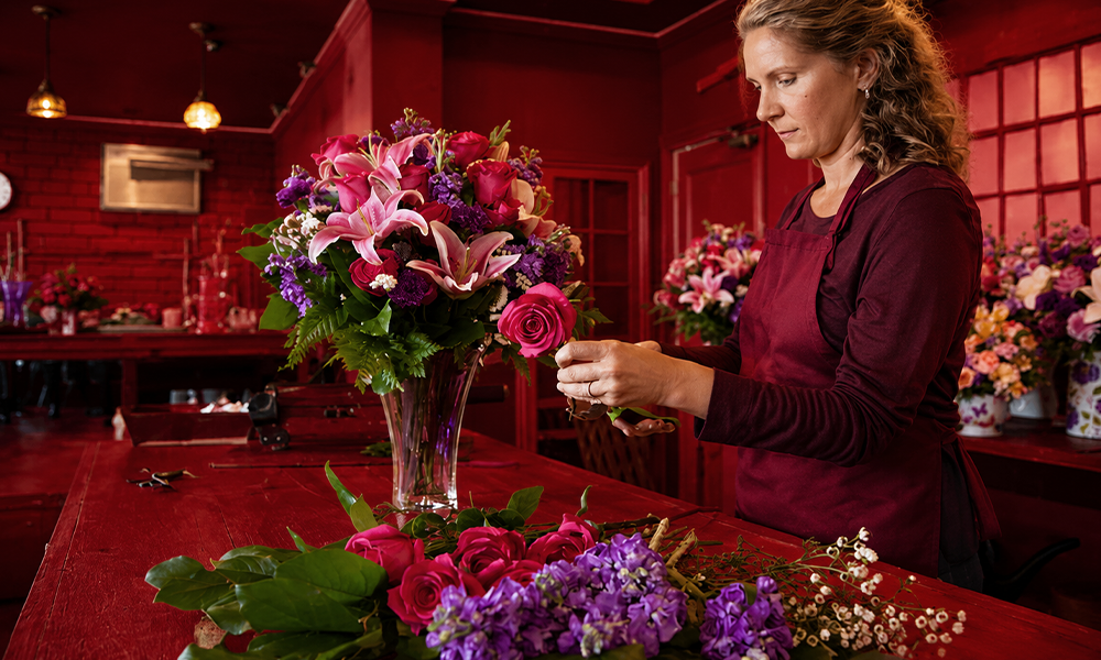 Florist arranging flowers in a workshop by Brand ClickX.