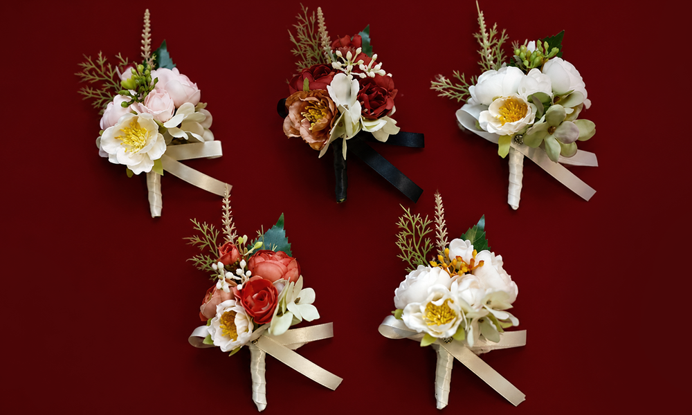| Corsage vs Boutonniere Guide: 2026 Trends, Styles & Buying Tips A set of elegant wedding boutonnieres against a deep red backdrop.