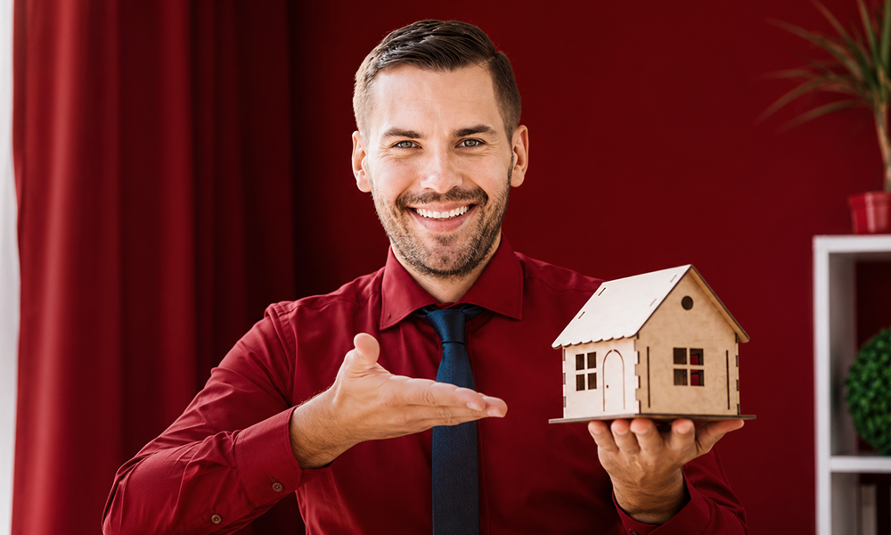 Real estate agent proudly presenting a miniature house model by Brand ClickX.