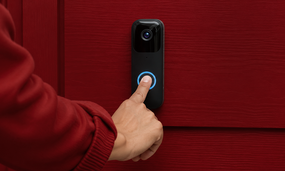 | 15 Best Video Doorbells Compared A person pressing the illuminated call button of a smart video doorbell mounted on a red exterior wall