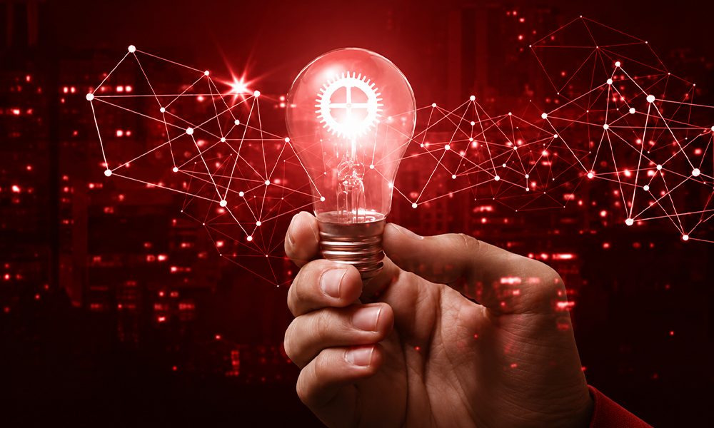 A hand holding a glowing lightbulb, symbolizing innovation.