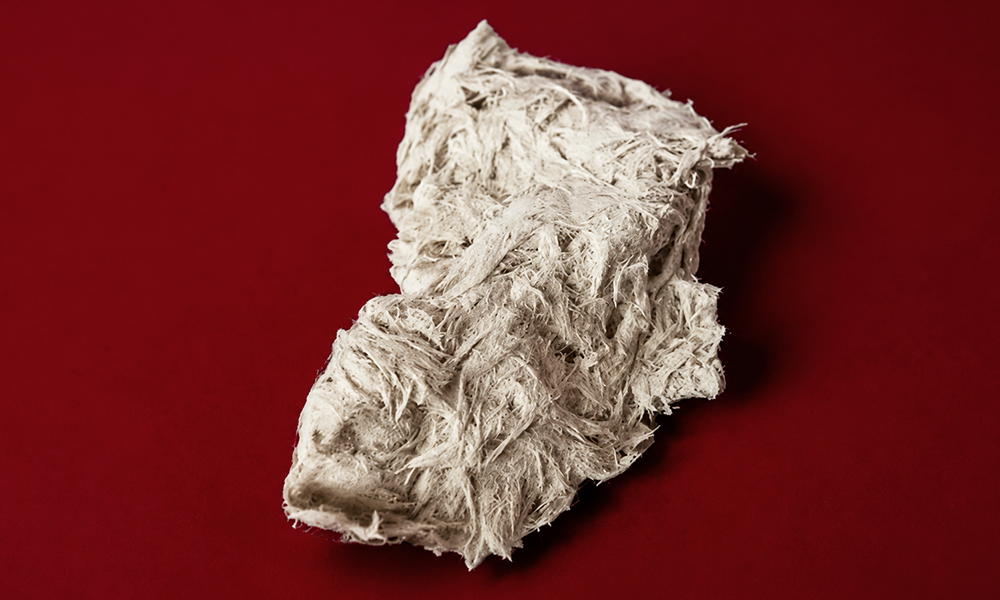 Textured white clay piece on a deep red surface by Brand ClickX.