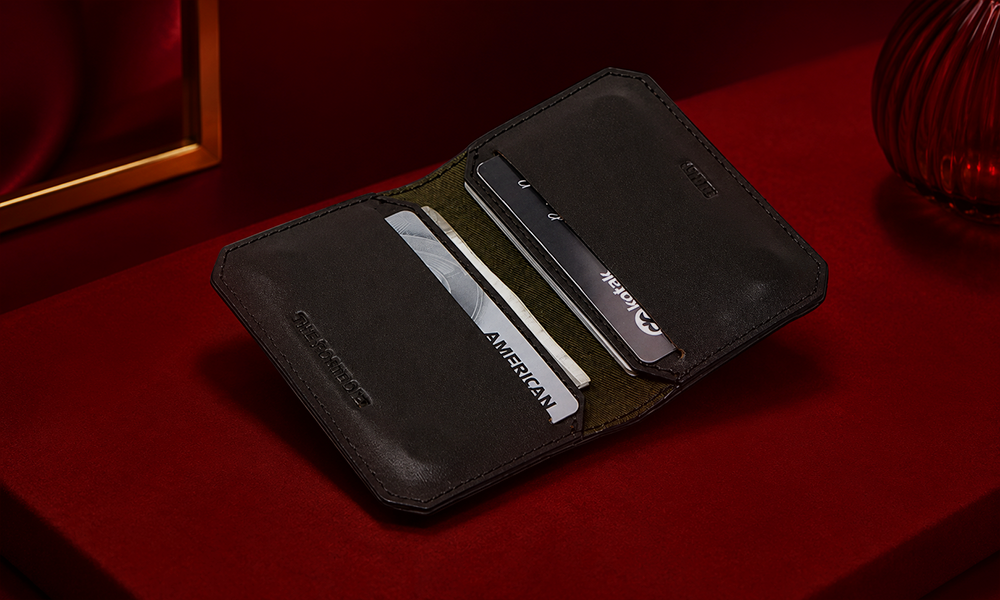 A leather wallet displayed on a dark red studio background.