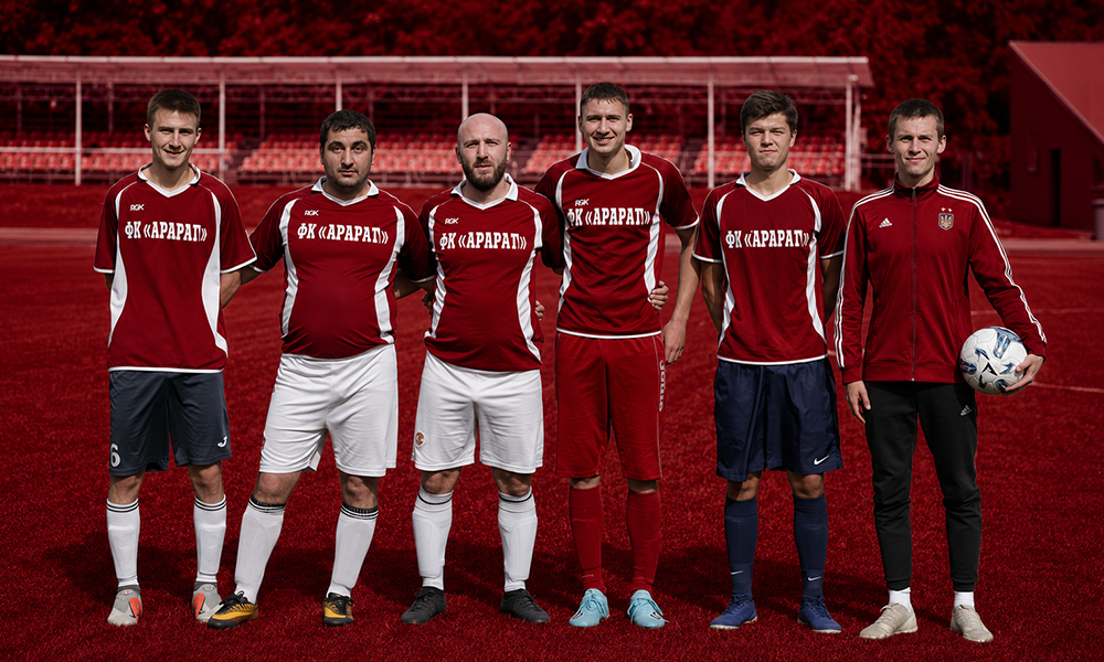 Football players team portrait on a deep red background by Brand ClickX.