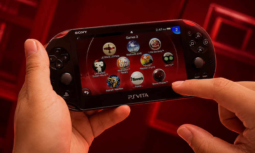 | 5 Tech Companies That Killed Iconic Products Prematurely Hands holding a Sony PS Vita handheld gaming console with game menu.