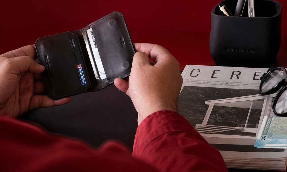 Hands placing cards into a wallet.