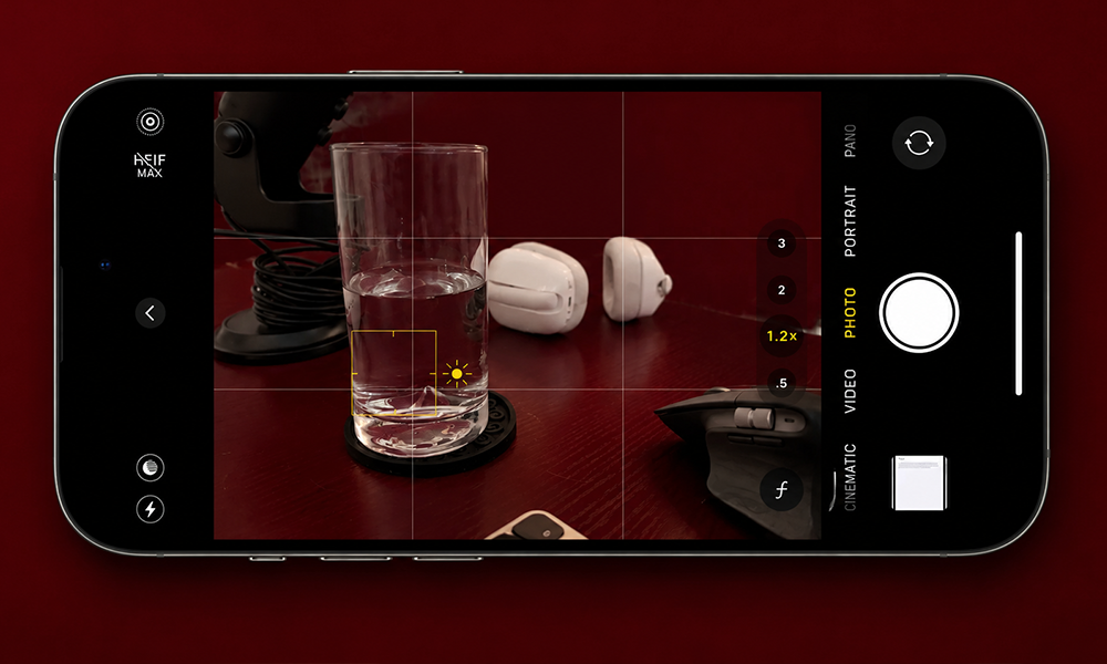 | Hidden iPhone Camera Tricks You Should Start Using Right Now Hand holding a smartphone displaying text next to an open book.