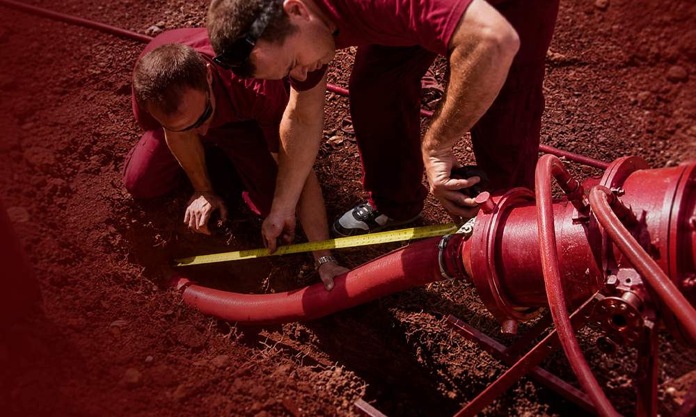 A technician servicing infrastructure within a deep trench.