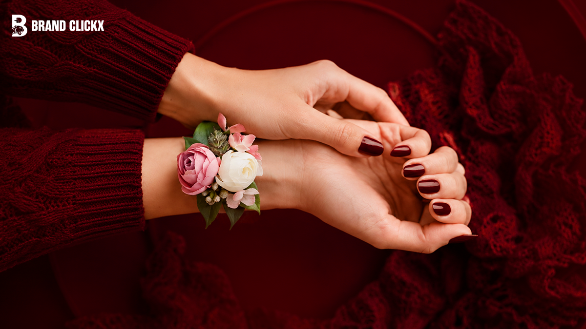 floral-corsage-on-wrist Close-up of a floral corsage worn on a wrist against a deep red background.