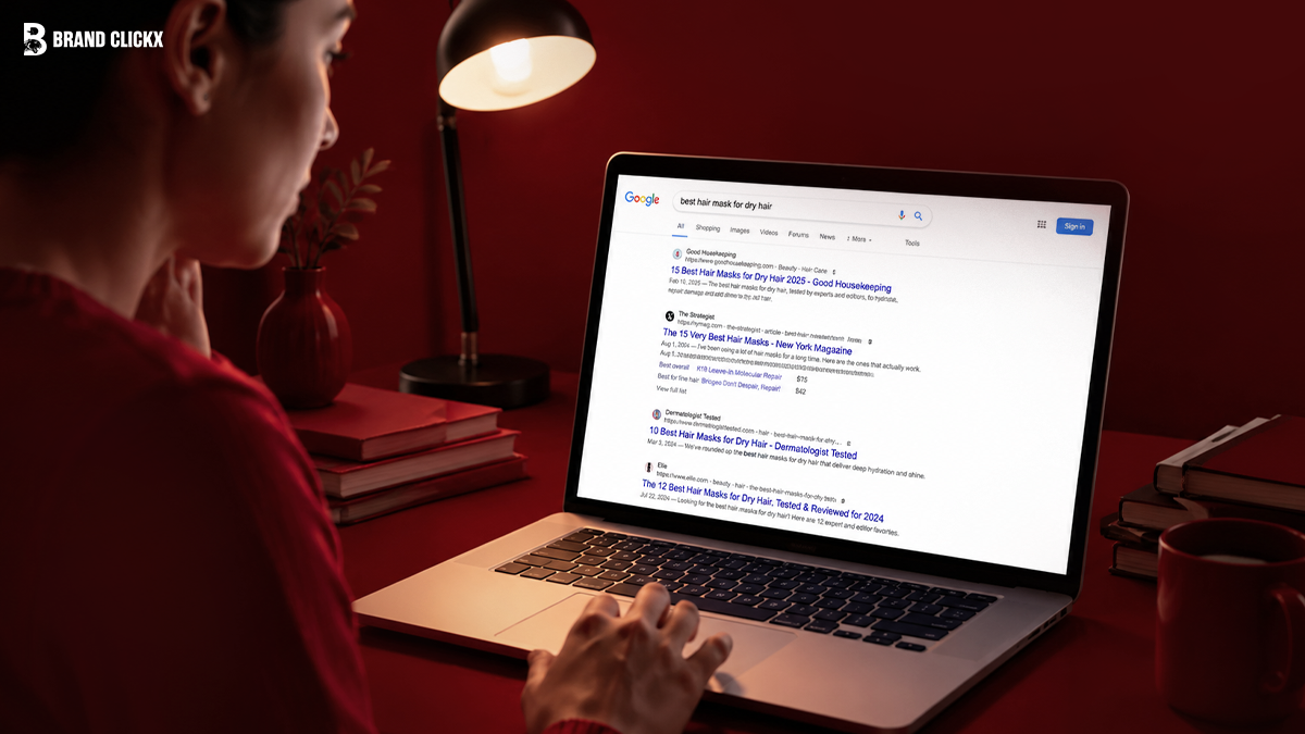 Woman using a laptop to search for best hair mask for dry hair on Google in a red-toned room setup