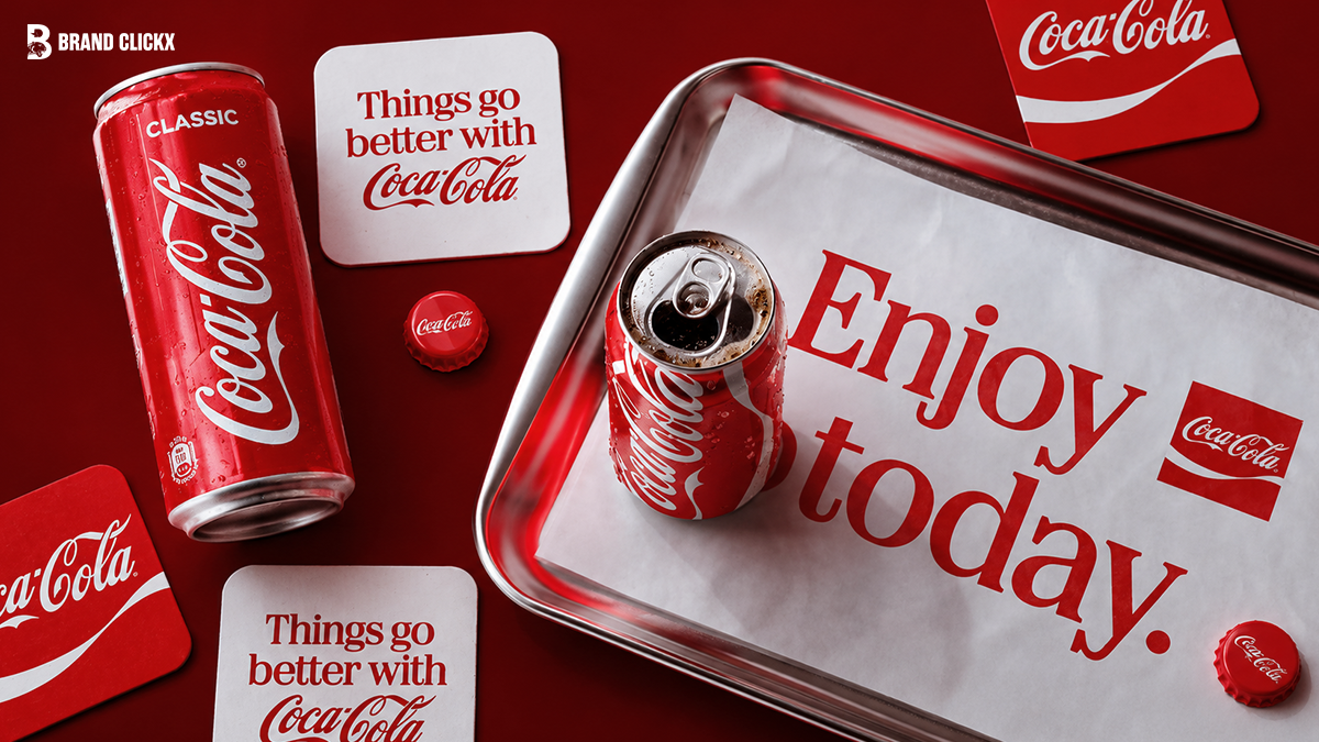 Flat lay of Coca-Cola classic cans, bottle caps, and coasters with branding slogans like Enjoy today and Things go better with Coca-Cola on a red surface