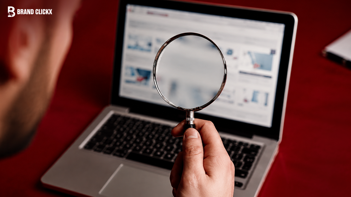Person using a magnifying glass to analyze a website on a laptop screen.