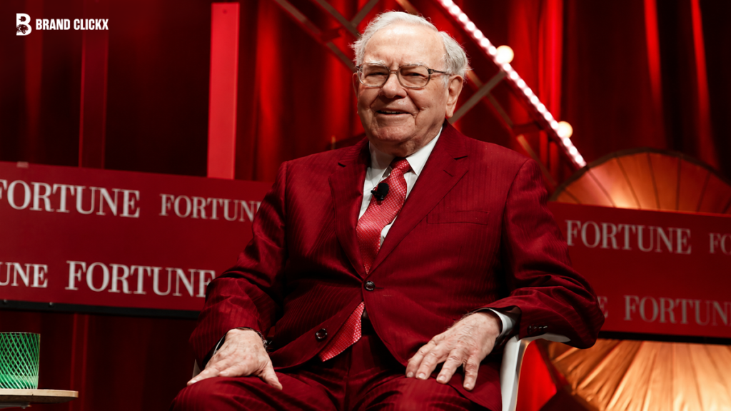 Warren Buffett sitting in a red suit at a Fortune conference.