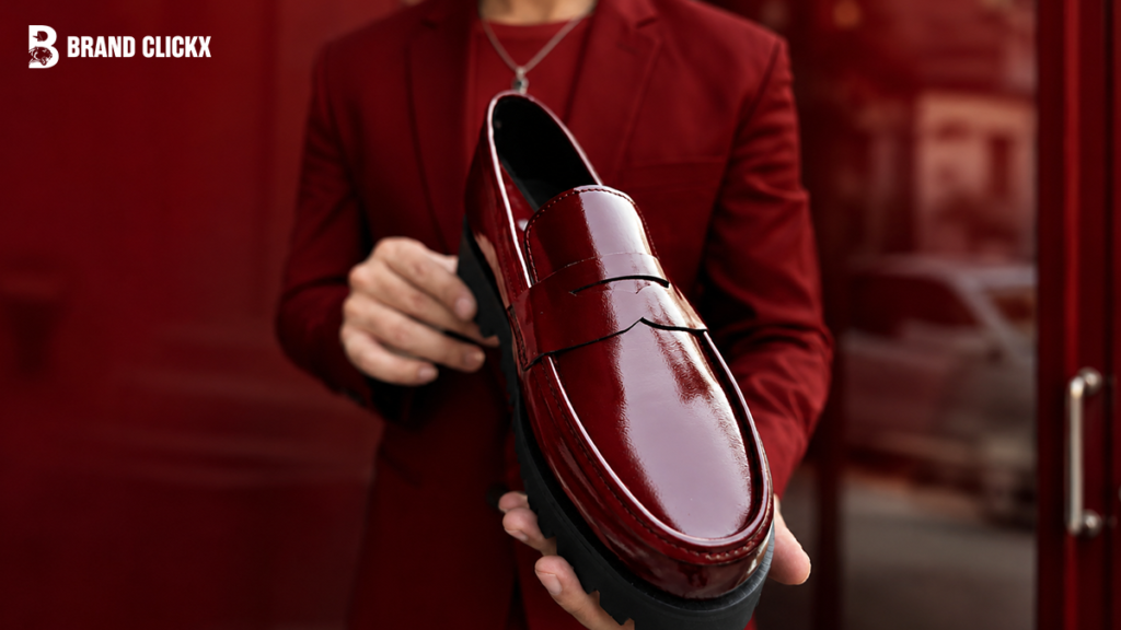 A close-up shot of a hand holding a formal leather shoe.