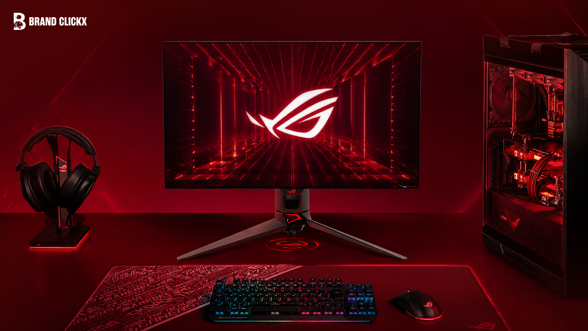 An ASUS ROG gaming setup with a monitor, PC, and peripherals in a red-themed room.
