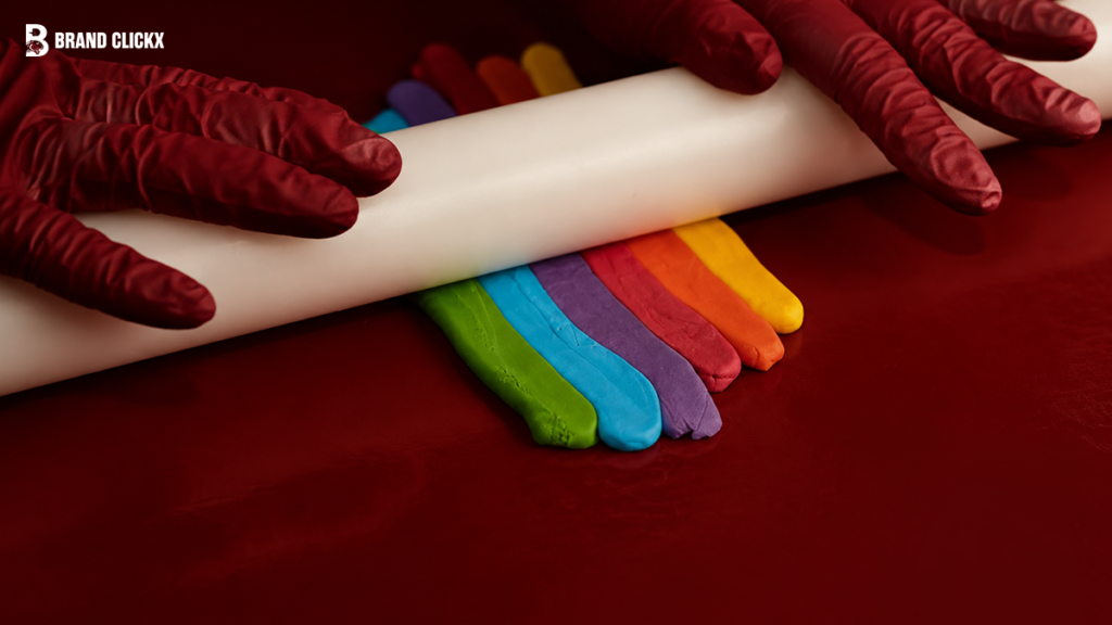 brand-clickx-clay-rolling-craft Rolling colorful clay on a deep red surface by Brand ClickX.