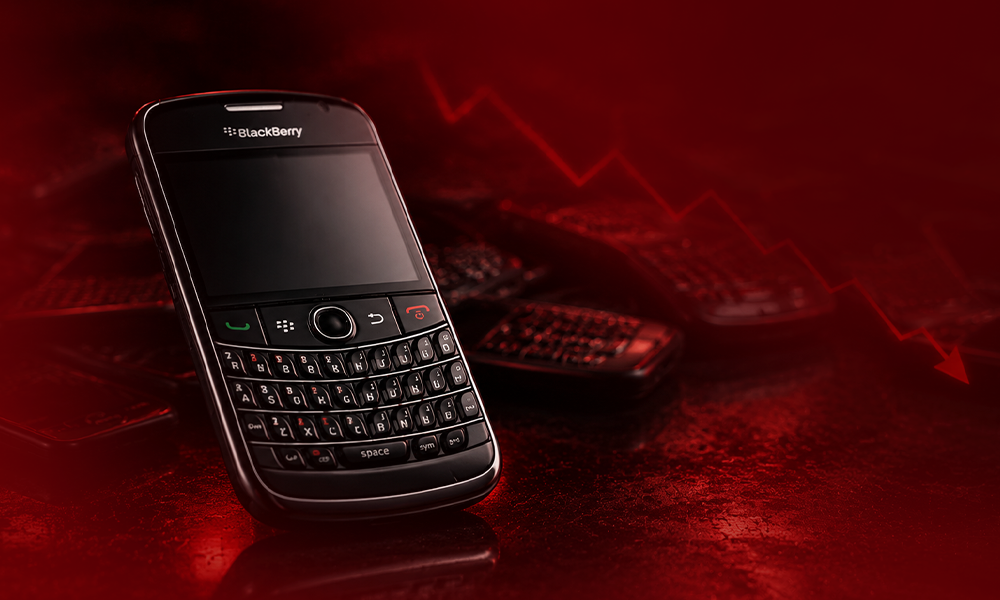 | 5 Biggest Tech Brand Failures That Shaped Industry Standards BlackBerry smartphone on a red background with a downward trend graph.