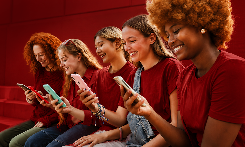 Diverse group of girls scrolling through social networks on smartphones