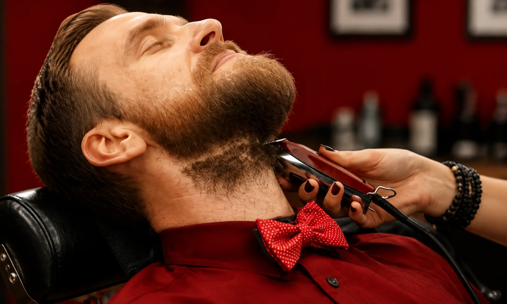 | Great Clips Near Me: Prices, Hours & Deals 2026 Close-up of a man getting a beard and neck cleanup in a red-lit salon chair