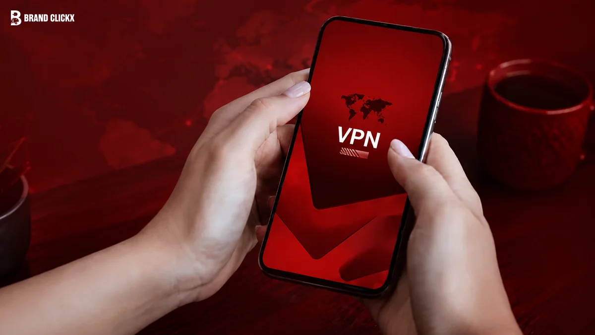 Hands holding a smartphone running a VPN app on a red-themed desk
