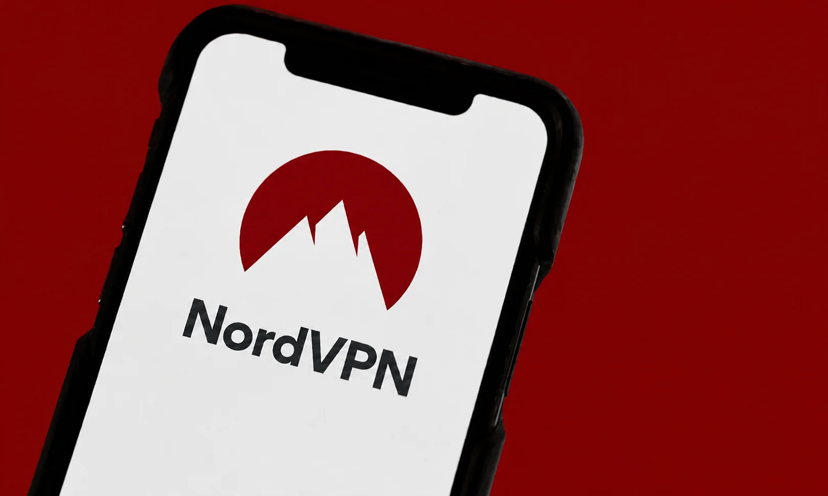A smartphone displaying the NordVPN app on a red surface