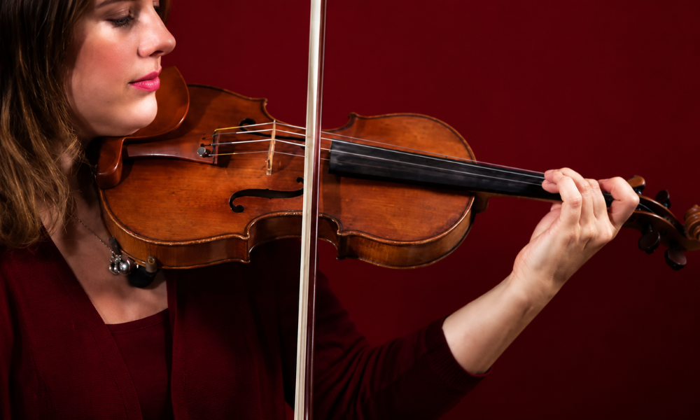Teacher giving violin lessons to a young student