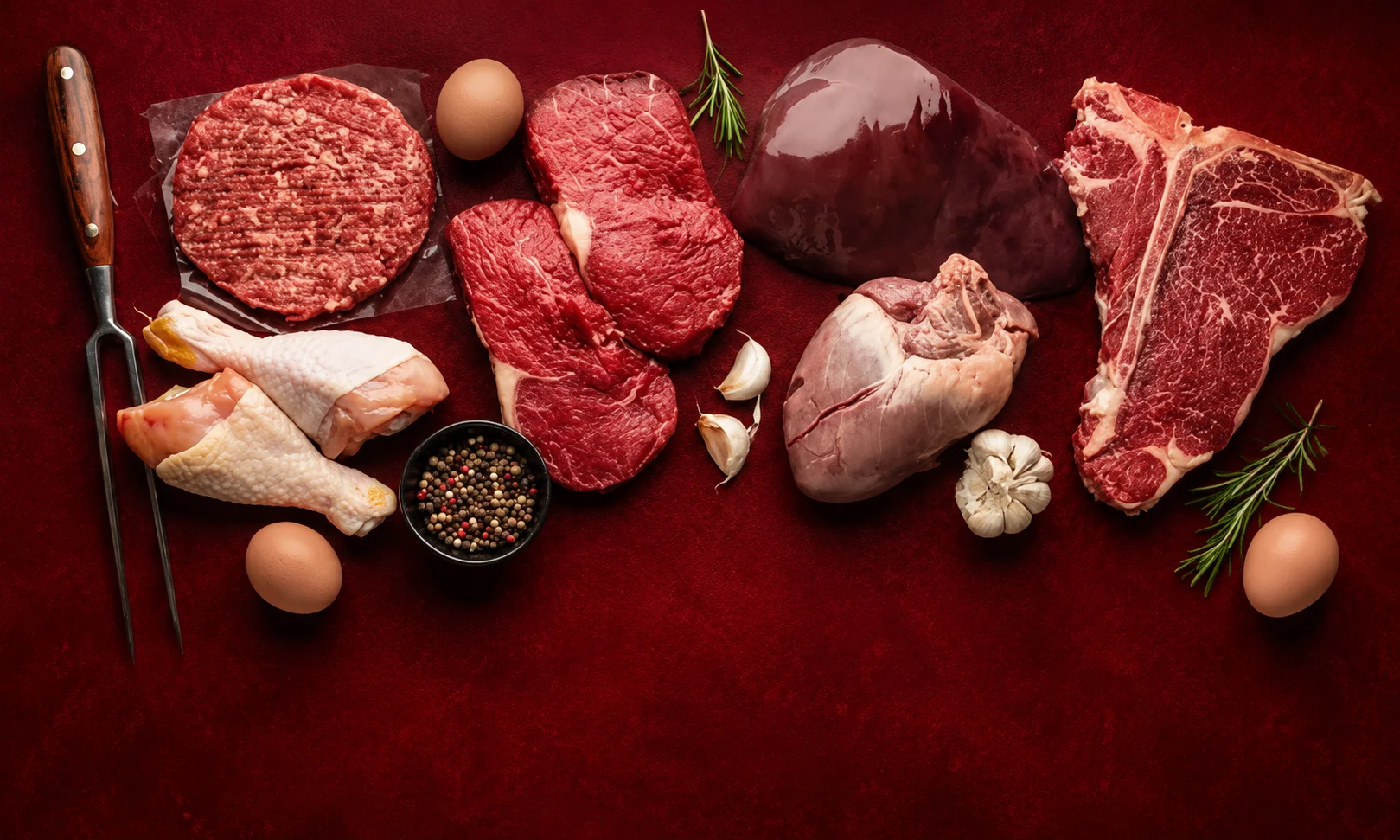 Selection of meat cuts and food items on a red surface