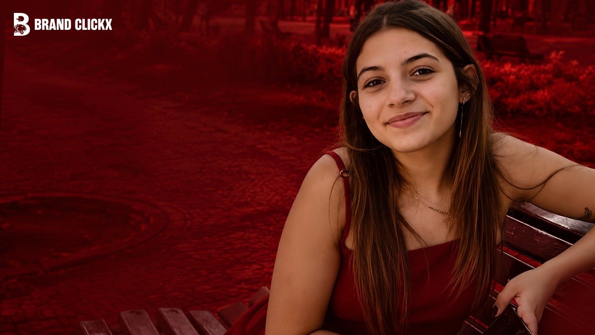 portrait-young-woman-red-backdro Portrait of a young woman smiling with Brand ClickX logo on red background.