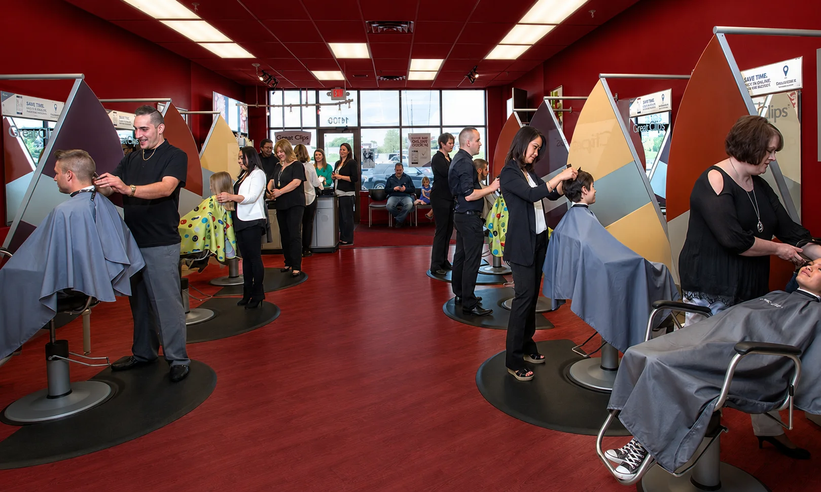 | Great Clips Near Me: Prices, Hours & Deals 2026 Interior view of a busy Great Clips salon with customers waiting under red ambient lighting
