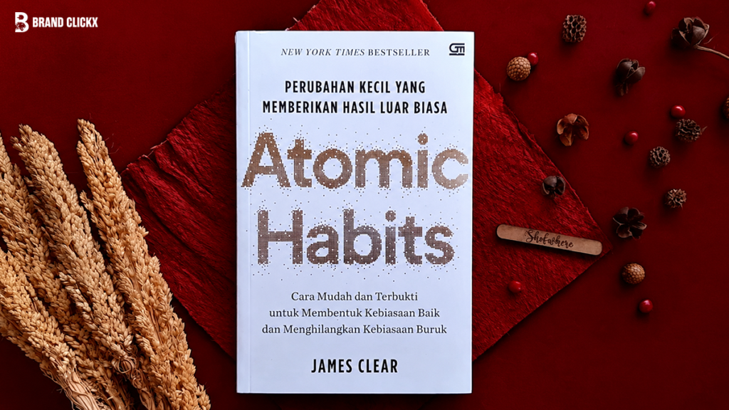 atomic-habits-book-by-james-clear Atomic Habits book cover by James Clear placed on a red background with decorative stalks