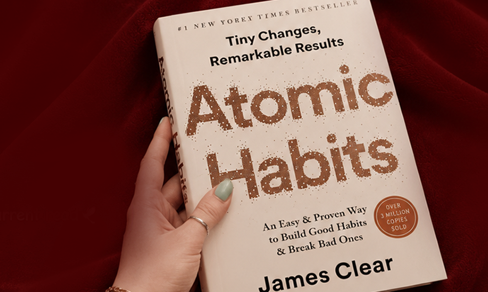 | Atomic Habits Summary: 25 Key Lessons & Actionable Takeaways A person holding the bestseller book Atomic Habits by James Clear featuring the tagline Tiny Changes Remarkable Results