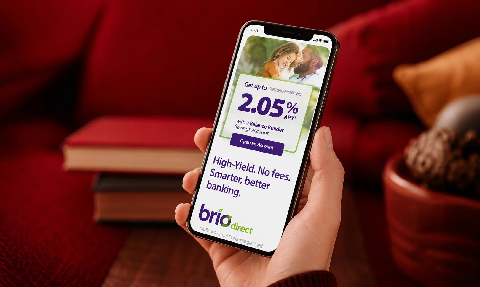 | 15 Best High-Yield Savings Accounts of August 2026 (Up to 4.21% APY) A phone displaying the BrioDirect banking portal against a warm background.