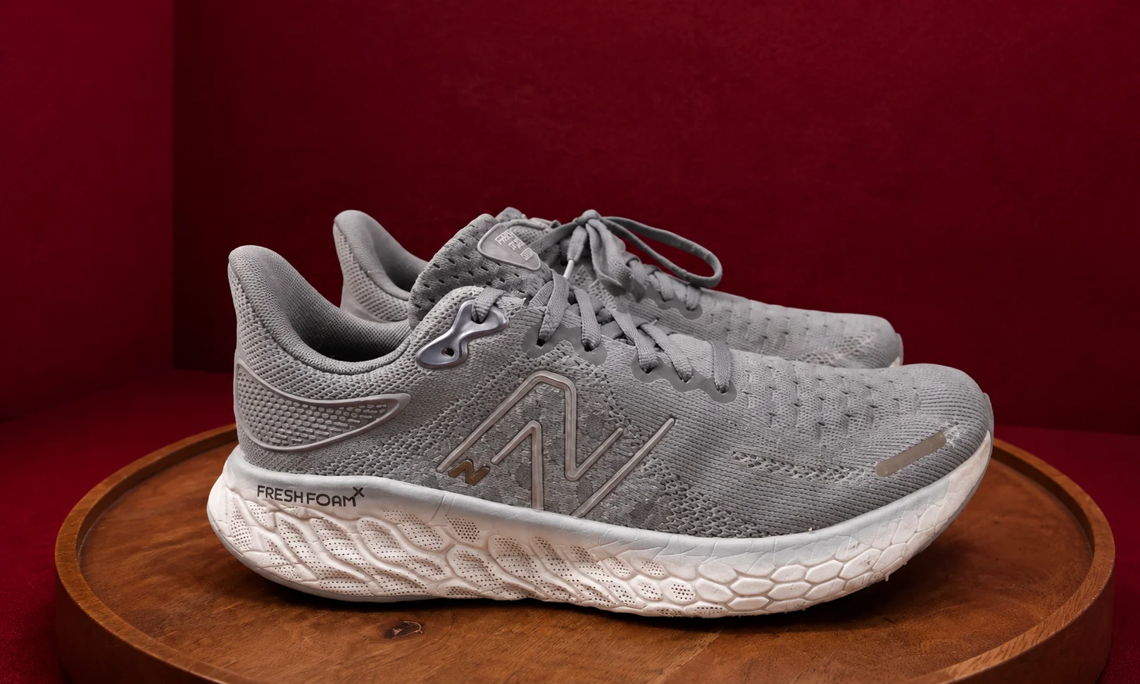 A pair of New Balance sneakers on a display base.