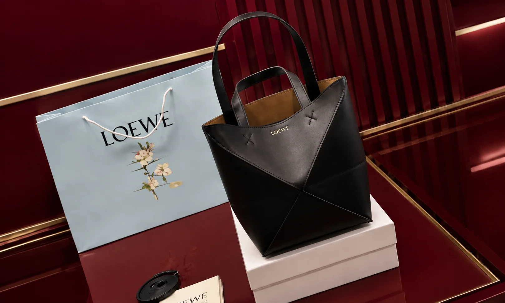 A Loewe luxury item set against a red background.